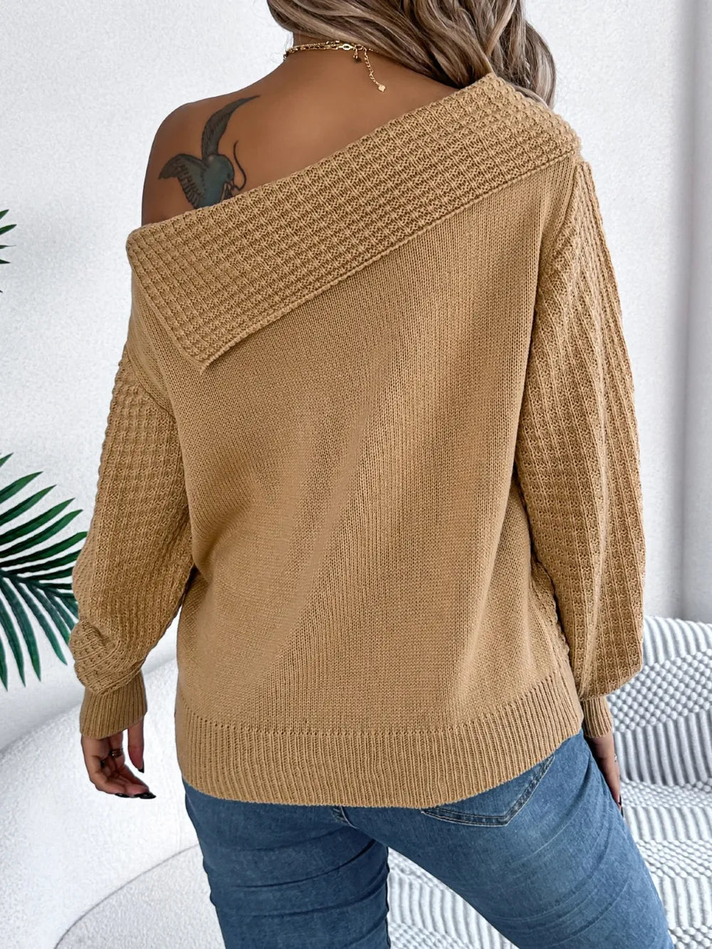Back view of cable knit one shoulder sweater soft textured knit pattern