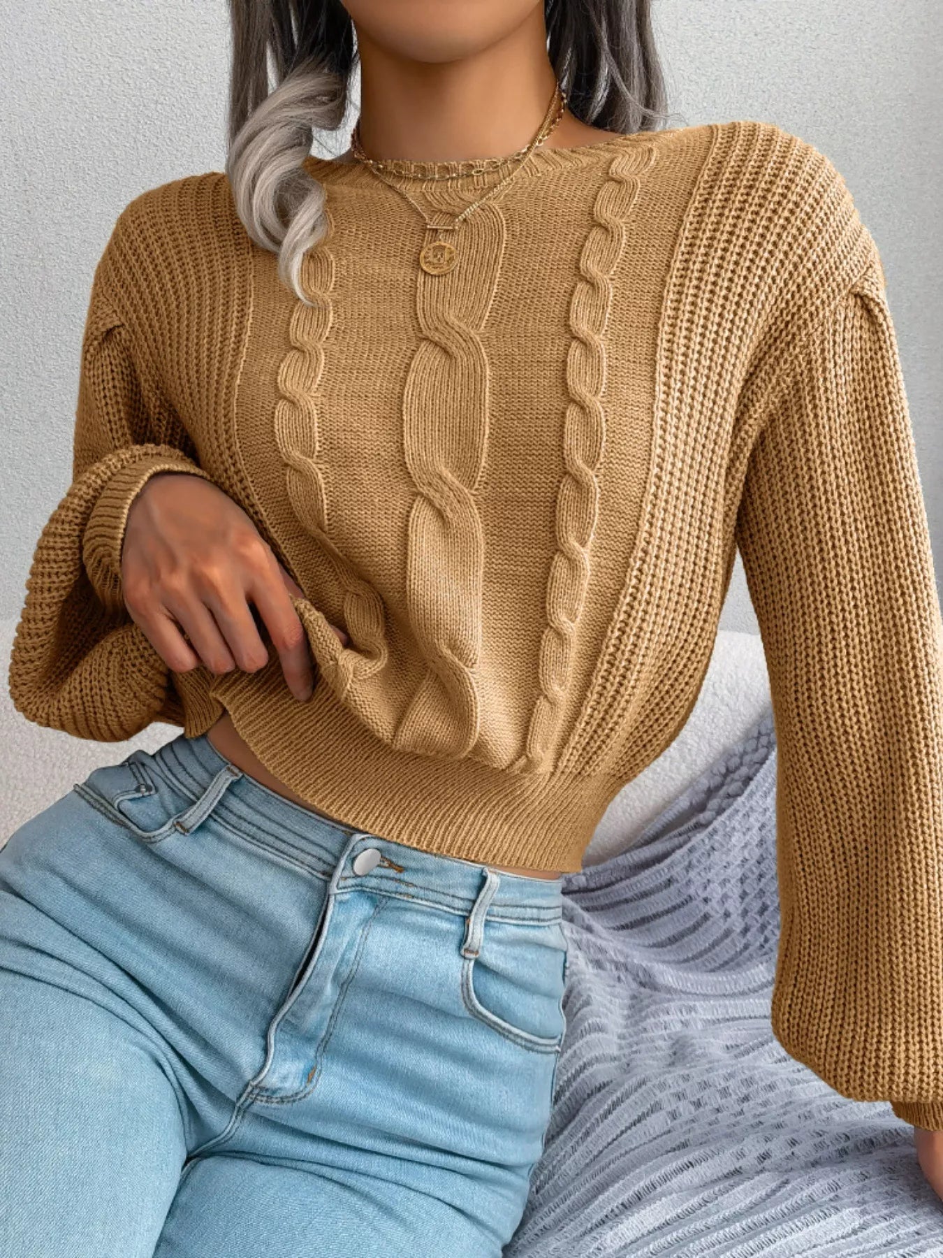 Detail of round neck cable knit sweater