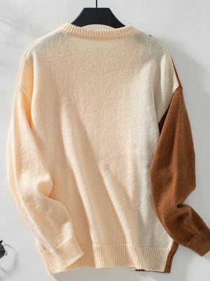 two tone cable knit sweater displayed on hanger