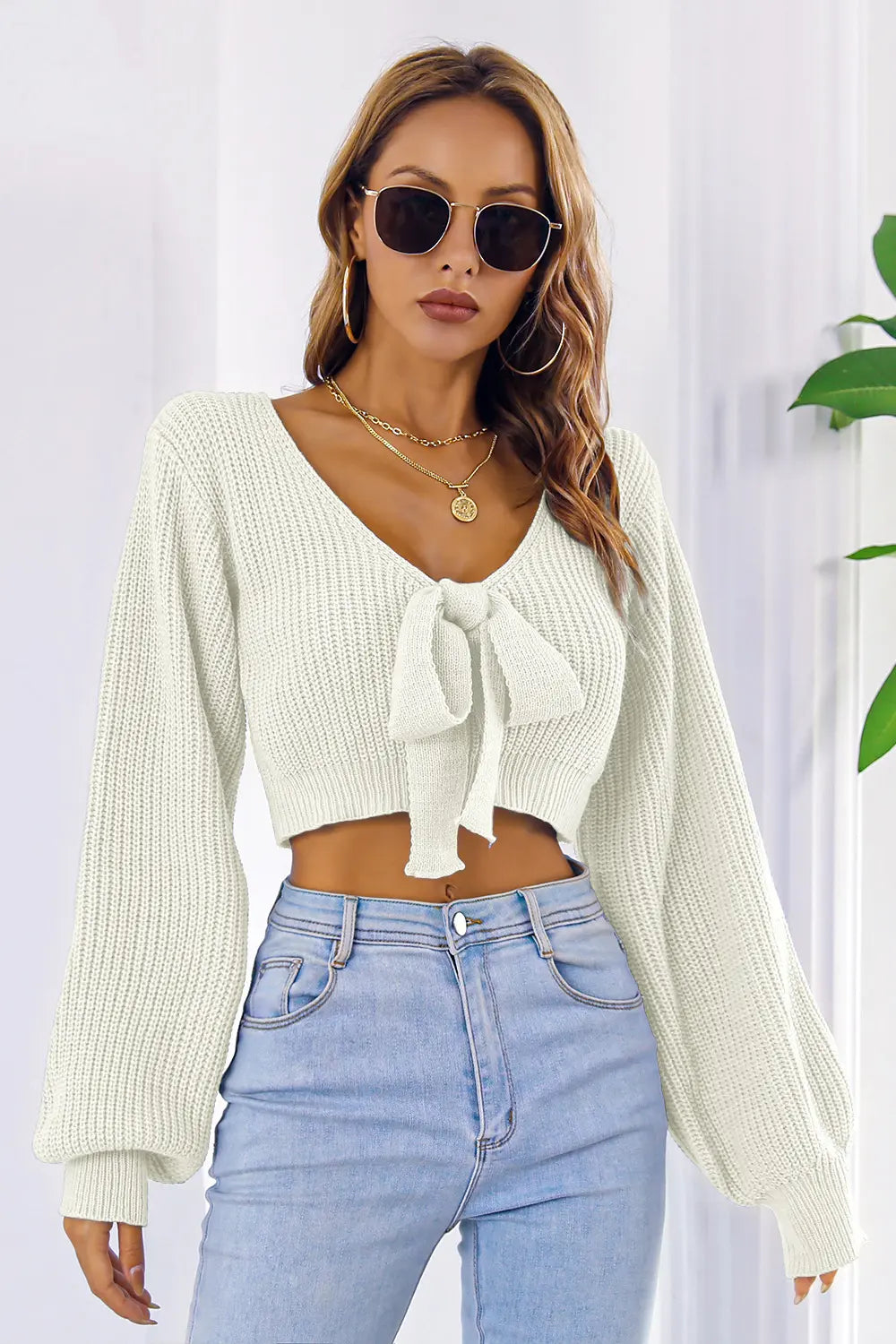 Front look of long sleeve cropped sweater with bow