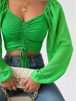 Front perspective showcasing cropped fit and sleeve style