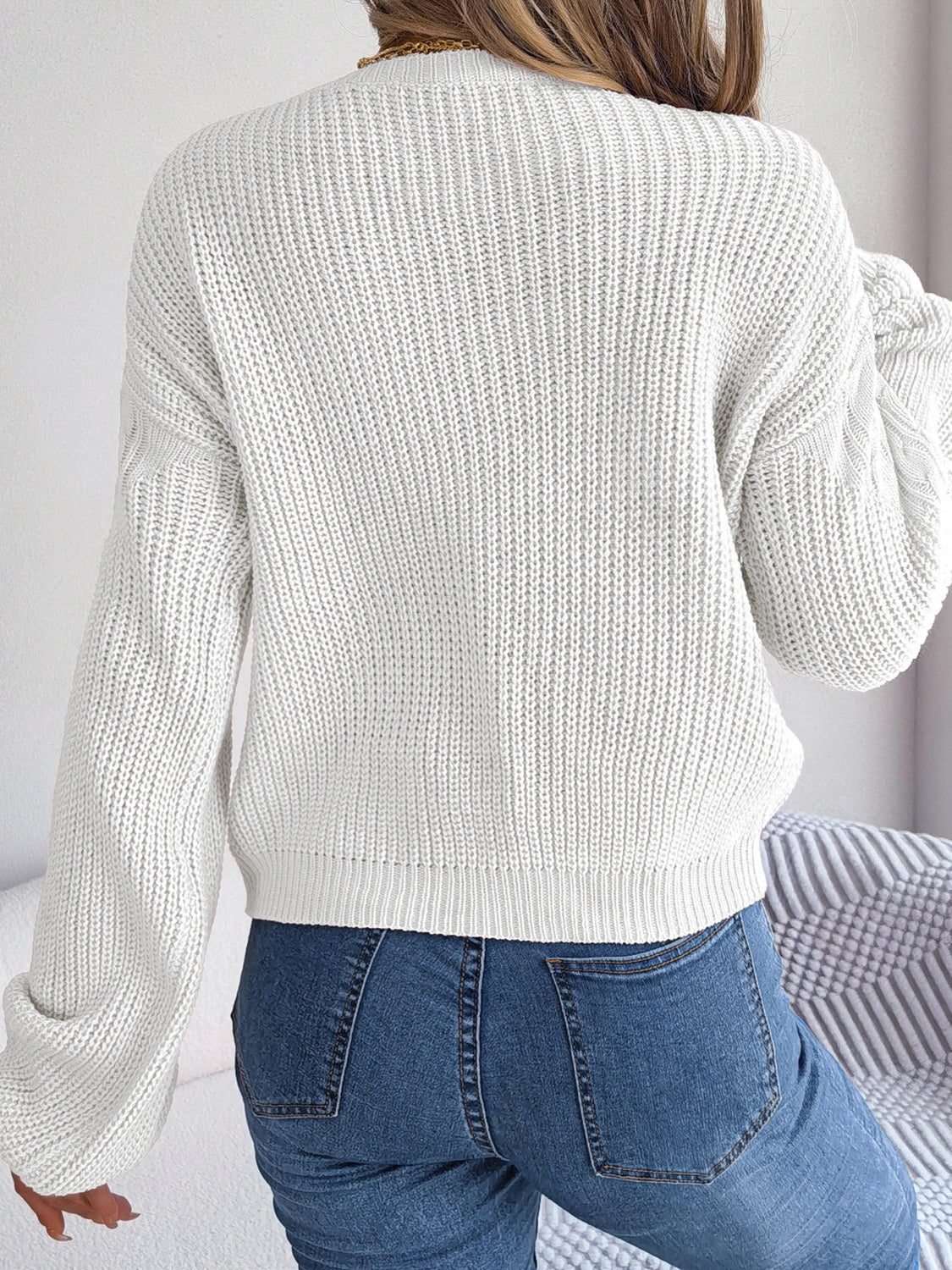Back view of cable knit sweater highlighting soft fabric and design