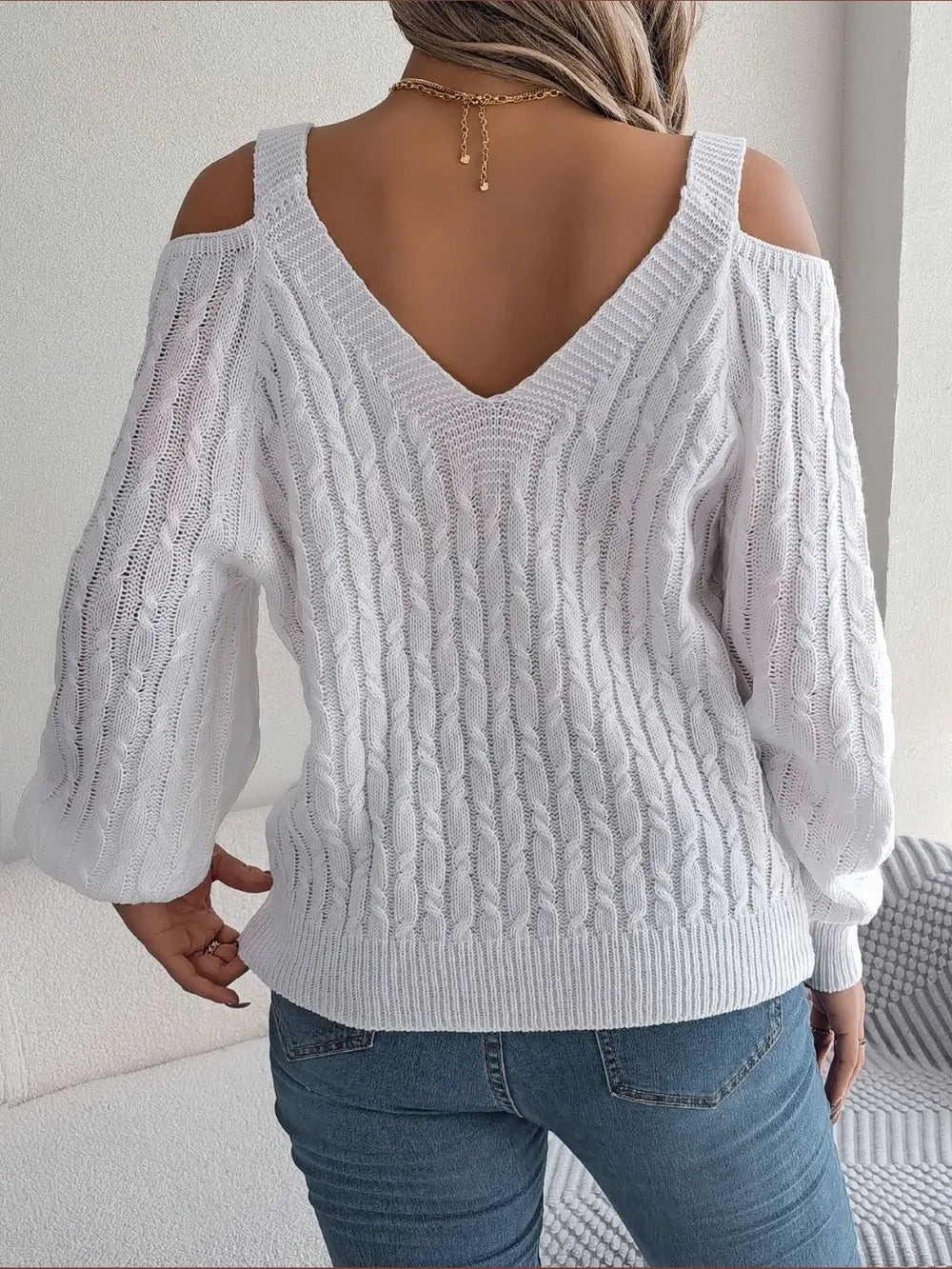 Back view of cable knit cold shoulder sweater showing shoulder cut design