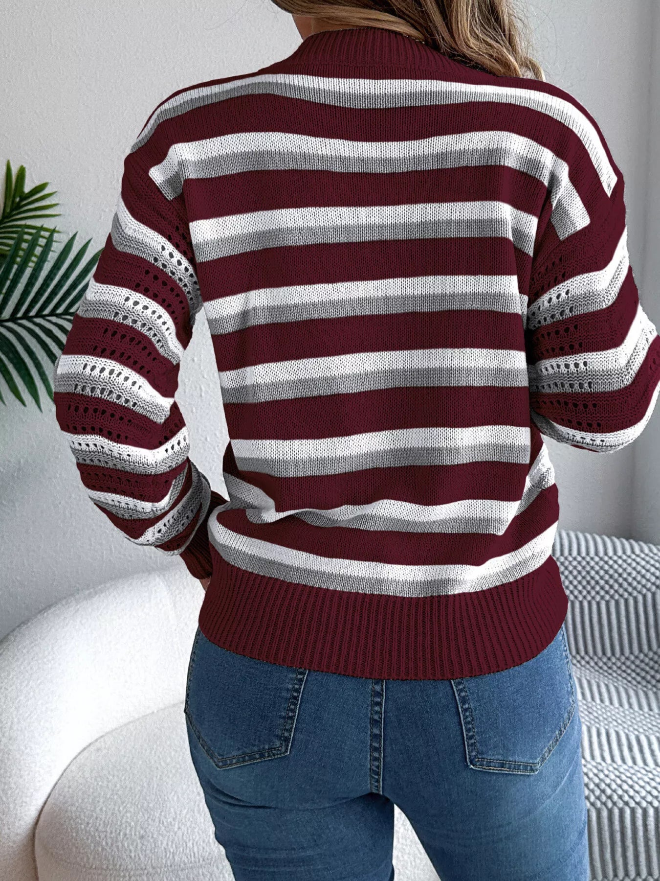 Rear view of striped round neck long sleeve knit sweater