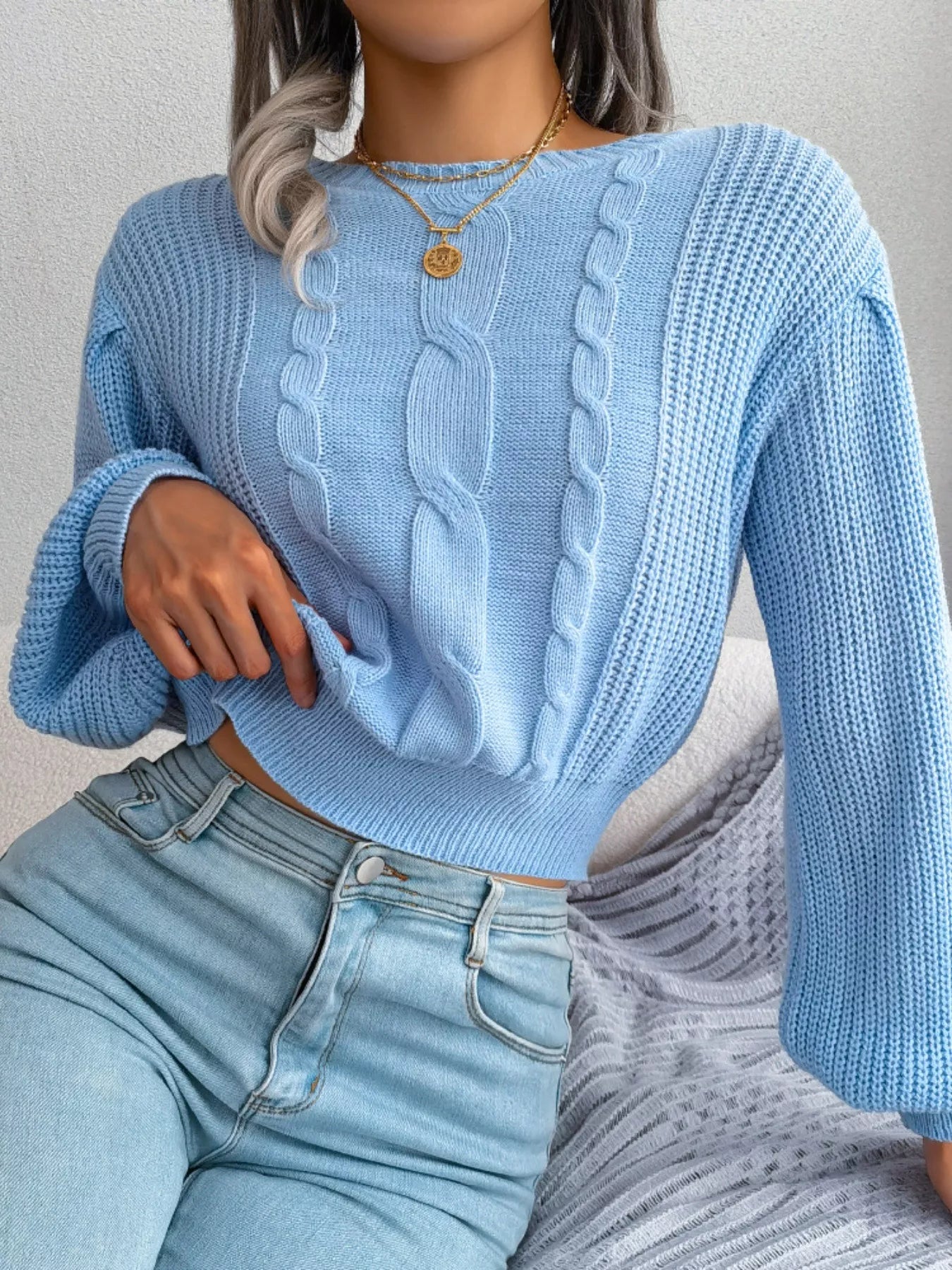 Side angled look of cable knit cropped sweater