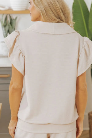 Back view of textured ruffled sleeve zipped top and pants set